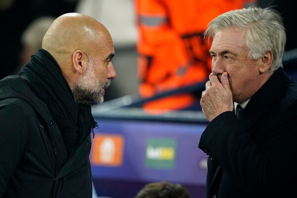 Real Madrid's head coach Carlo Ancelotti, right, talks to Manchester City's head coach Pep Guardiola before the start of the Champions League playoff first leg soccer match between Manchester City and Real Madrid at the Etihad Stadium in Manchester, England, Tuesday, Feb. 11, 2025. (AP Photo/Dave Thompson)