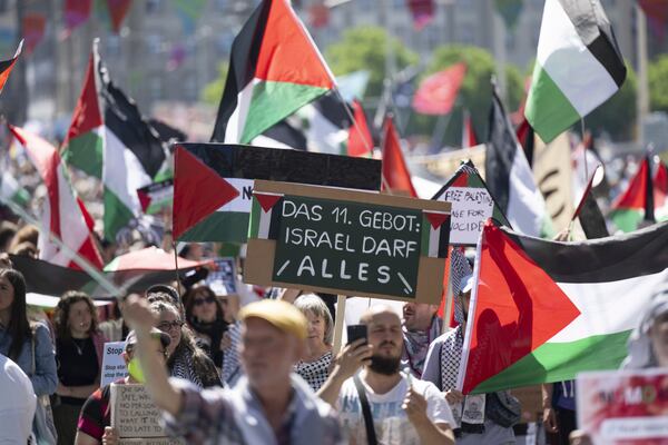 Pro Palestinian protesters demonstrate, during the opening ceremony of the 69th Eurovision Song Contest, in Basel, Switzerland, Sunday, May 11, 2025. Sign read, '11th Commandment: Israel is allowed to do everything.' (Georgios Kefalas/Keystone via AP)