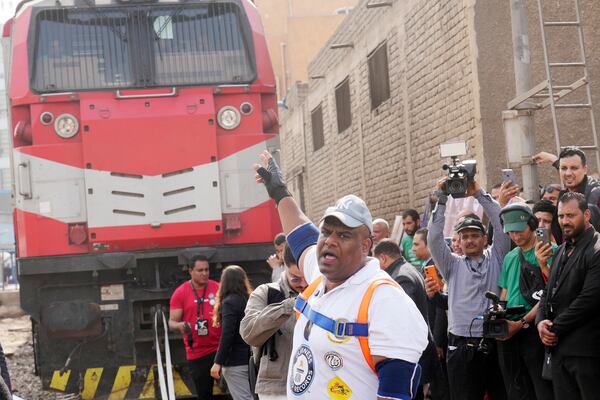 Egyptian wrestler Ashraf Mahrous, better known as Kabonga, greets his fans after he pulled a train for nearly 10 meters, 33 feets, at Ramses Station in Cairo, Egypt, Thursday, March 13, 2025. (AP Photo/Amr Nabil)