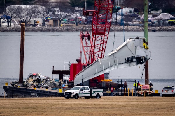 Salvage crews work near the wreckage site in the Potomac River of a mid-air collision between an American Airlines jet and a Black Hawk helicopter, at Ronald Reagan Washington National Airport, Wednesday, Feb. 5, 2025, in Arlington, Va. (AP Photo/Ben Curtis)