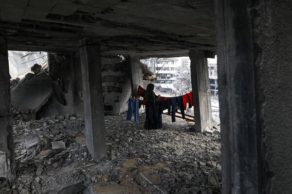 A Palestinian woman hangs the laundry inside her home, which was destroyed in the Israeli bombardment of the Gaza Strip, Tuesday, Jan. 28, 2025. (AP Photo/Jehad Alshrafi)