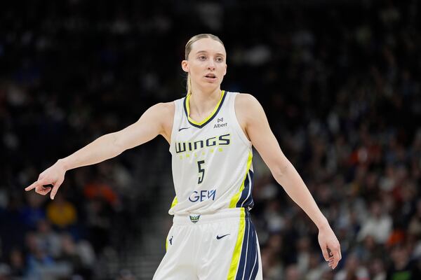 Dallas Wings guard Paige Bueckers (5) points during the first half of a WNBA basketball game against the Minnesota Lynx, Wednesday, May 21, 2025, in Minneapolis. (AP Photo/Abbie Parr)