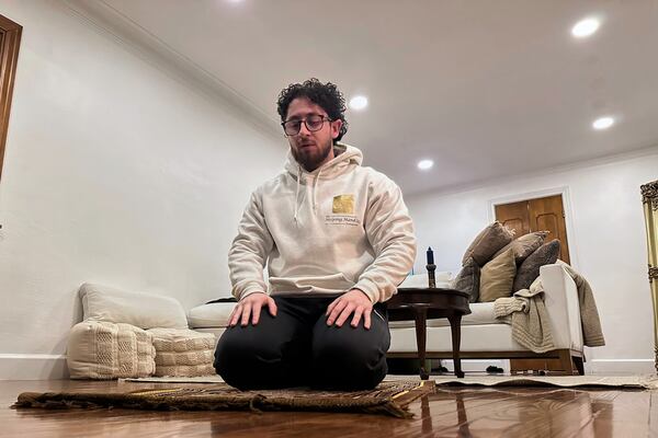 The Helping Handzzz Foundation board member Daoud Wehbi prays in a home following an iftar meal Friday, March 7, 2025, in Dearborn, Mich. (AP Photo/Mike Householder)