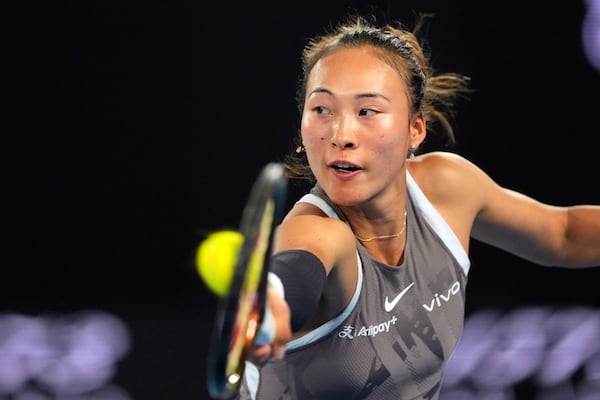 Zheng Qinwen of China plays a backhand return to Anca Todoni of Romania during their first round match at the Australian Open tennis championship in Melbourne, Australia, Sunday, Jan. 12, 2025. (AP Photo/Vincent Thian)