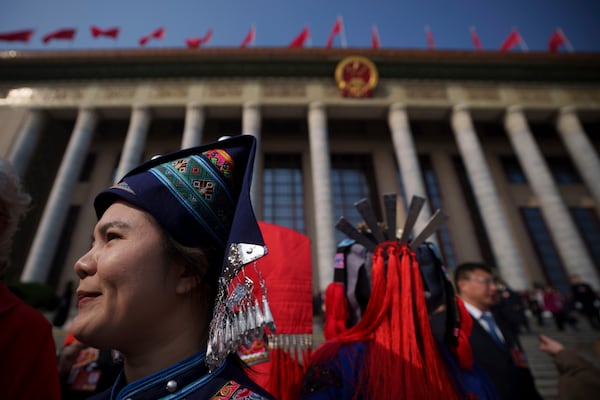 Female ethnic minority delegates leave after the opening session of the National People's Congress (NPC) at the Great Hall of the People in Beijing, China, Wednesday, March 5, 2025. (AP Photo/Vincent Thian)