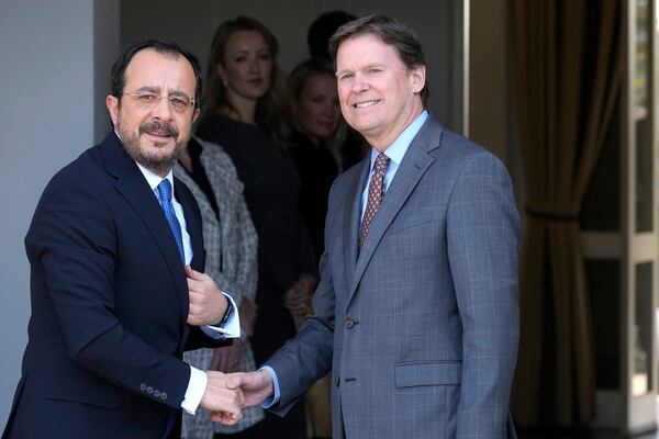 United Nations Chief of Mission in Cyprus Colin Stewart, right, shakes hands with the Cypriot President Nikos Christodoulides as he arrives for a meeting with the leader of the breakaway Turkish Cypriots Ersin Tatar at the U.N. official's residence inside a U.N.-controlled buffer zone cutting across the divided capital Nicosia, Cyprus, Monday, Jan. 20, 2025. (AP Photo/Petros Karadjias)