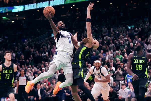 Dallas Mavericks guard Kyrie Irving (11) drives to the basket against Boston Celtics guard Jordan Walsh during the second half of an NBA basketball game, Thursday, Feb. 6, 2025, in Boston. (AP Photo/Charles Krupa)