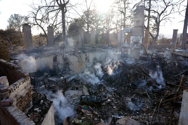 Smoke rises from the charred remains of a structure at the Pasadena Waldorf School campus, Sunday, Jan. 12, 2025, in Altadena, Calif. (AP Photo/Chris Pizzello)