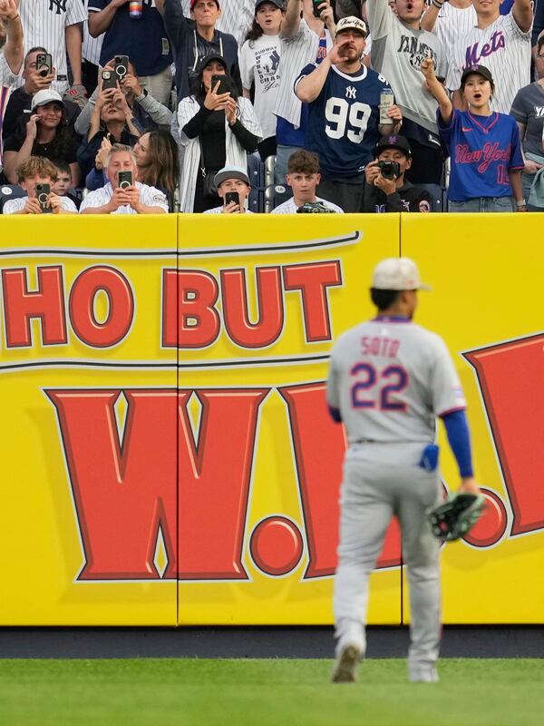 Fans react as New York Mets' Juan Soto (22) makes his way to right field during the first inning of a baseball game against the New York Yankees, Friday, May 16, 2025, in New York. (AP Photo/Seth Wenig)