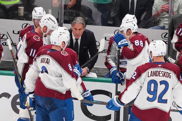 Colorado Avalanche head coach Jared Bednar, center, instructs Cale Makar (8), Gabriel Landeskog (92) and others during a time out in the third period in Game 7 of a first-round NHL hockey playoff series against the Dallas Stars Saturday, May 3, 2025, in Dallas. (AP Photo/Julio Cortez)