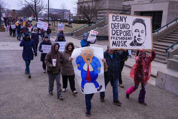 Protestors march around the Statehouse in Indianapolis, Wednesday, Feb. 5, 2025 during a protest rally against Project 2025. (AP Photo/Michael Conroy)