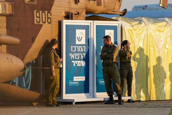 Israeli soldiers stand next to an Israeli military helicopter carrying five Thai hostages released from Gaza after landing at Shamir Medical Center (Assaf Harofeh) in Be'er Ya'akov, Israel, Thursday, Jan. 30, 2025. (AP Photo/Maya Alleruzzo)