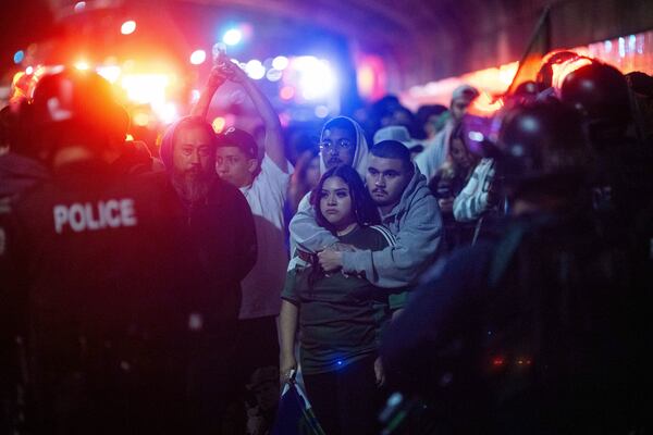 Police detain demonstrators as they are escorted away during an immigration rights protest in Los Angeles, Feb. 3, 2025. (AP Photo/Ethan Swope)