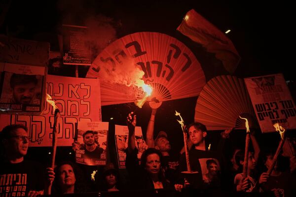 Demonstrators light flares during a protest demanding a cease-fire deal and the immediate release of hostages held by Hamas in the Gaza Strip, Saturday, May 10, 2025, in Tel Aviv, Israel. (AP Photo/Oded Balilty)
