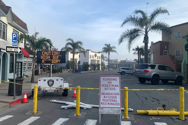 A street is closed due to high surf conditions near Capitola Beach, Monday, Dec. 23, 2024, in Capitola, Calif. (AP Photo/Pamela Hassell)