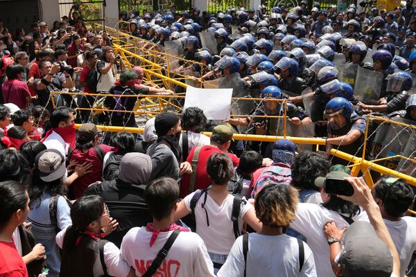 Activists and workers remove barricades as they try to march towards the Malacanang presidential palace during a May Day rally in Manila, Philippines on Thursday, May 1, 2025. (AP Photo/Aaron Favila)
