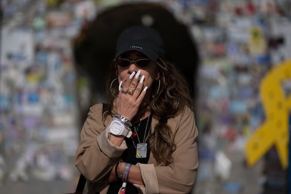 A woman reacts as people gather in Tel Aviv, Israel, on the first day of a ceasefire between Israel and Hamas, where three hostages are set to be released from captivity in the Gaza Strip, Sunday, Jan. 19, 2025. (AP Photo/Maya Alleruzzo)