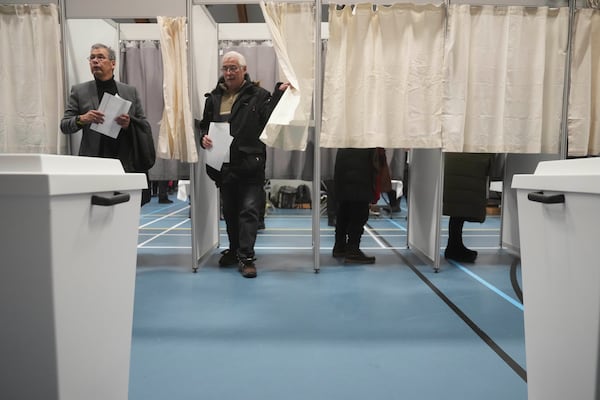 People stand in booths at a polling station as the prepare to cast their vote in parliamentary elections, in Nuuk, Greenland, Tuesday, March 11, 2025. (AP Photo/Evgeniy Maloletka)