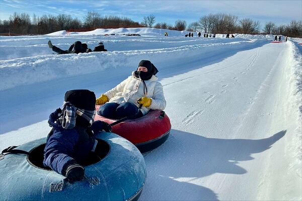 Jorida Latifi and her 7-year-old son ride on snow tubes during an outing organized by a group that promotes outdoors activities for Muslim women at Elm Creek Park Reserve in Maple Grove, Minn., on Jan. 4, 2025. (AP Photo/Mark Vancleave)