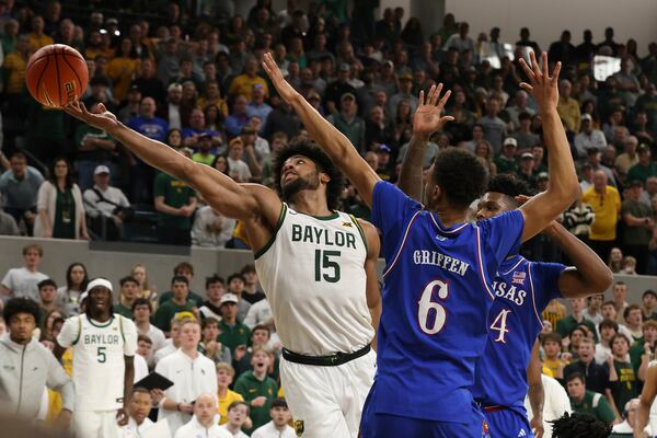 Baylor forward Norchad Omier (15) reaches for the ball wile being guarded by Kansas forward KJ Adams Jr., right, and guard Rylan Griffen (6) during the second half of an NCAA college basketball game Saturday, Feb. 1, 2025, in Waco, Texas. (AP Photo/Jerry Larson)