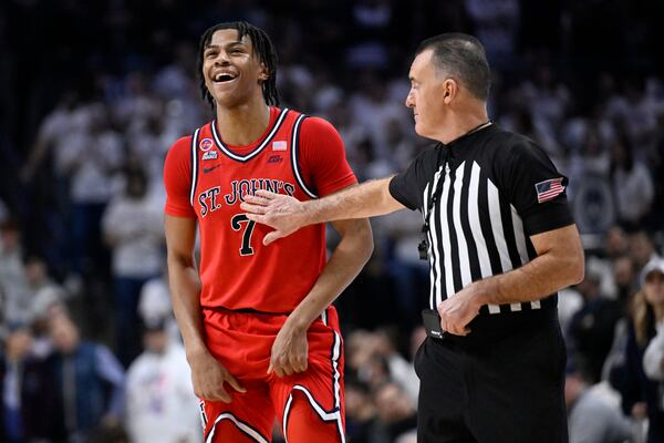 St. John's guard Simeon Wilcher (7) shares a light moment with referee Roger Ayers in the second half of an NCAA college basketball game against UConn, Friday, Feb. 7, 2025, in Storrs, Conn. (AP Photo/Jessica Hill)