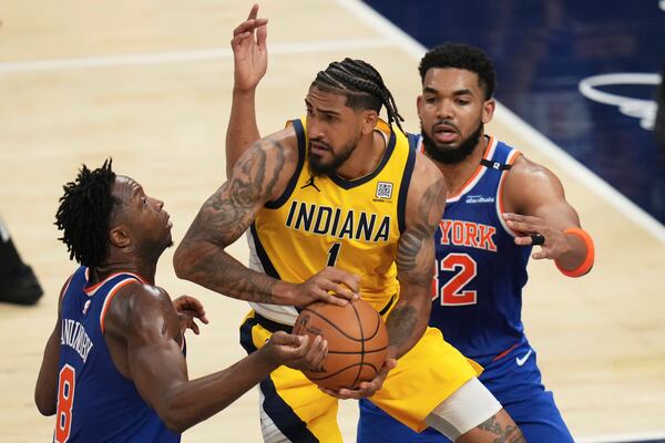 Indiana Pacers forward Obi Toppin (1) looks to pass the ball between New York Knicks forward OG Anunoby, left, and center Karl-Anthony Towns during the second half of Game 3 of the Eastern Conference finals of the NBA basketball playoffs Sunday, May 25, 2025, in Indianapolis. (AP Photo/Jeff Roberson)