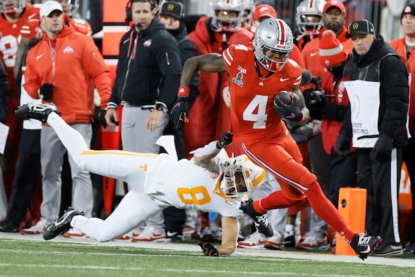 Tennessee linebacker Kalib Perry, left, forces Ohio State receiver Jeremiah Smith (4) out of bounds during the first half in the first round of the College Football Playoff, Saturday, Dec. 21, 2024, in Columbus, Ohio. (AP Photo/Jay LaPrete)