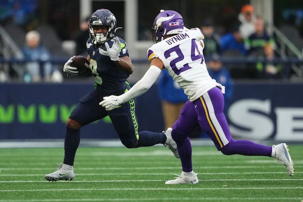 Seattle Seahawks running back Kenneth Walker III (9) runs with the football as Minnesota Vikings safety Camryn Bynum (24) tries to tackle during the second half of an NFL football game, Sunday, Dec. 22, 2024, in Seattle. (AP Photo/Lindsey Wasson)