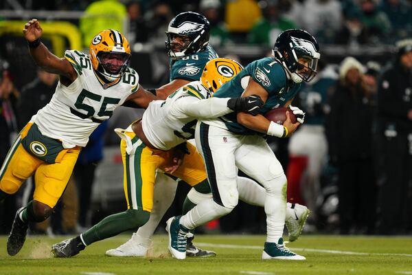 Philadelphia Eagles quarterback Jalen Hurts (1) is sacked by Green Bay Packers defensive end Rashan Gary (52) as Green Bay Packers defensive end Kingsley Enagbare (55) narrows in during the second half of an NFL wild-card playoff football game Sunday, Jan. 12, 2025, in Philadelphia. (AP Photo/Derik Hamilton)