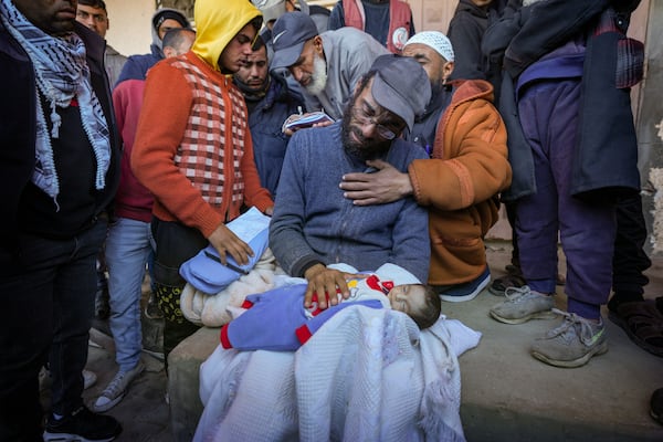 EDS NOTE: GRAPHIC CONTENT - Yehia al-Batran grieves as he holds the body of his 20-day-old son Jomaa, who died from hypothermia, at Al-Aqsa Martyrs Hospital in central Gaza, Sunday, Dec. 29, 2024. Jomaa's twin brother, Ali, remains in intensive care, as local health officials report at least three other infant deaths from the cold in recent weeks. (AP Photo/Abdel Kareem Hana)