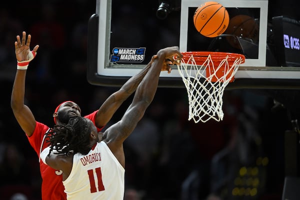 Robert Morris guard Amarion Dickerson, back, defends a shot by Alabama center Clifford Omoruyi (11) in the first half in the first round of the NCAA college basketball tournament, Friday, March 21, 2025, in Cleveland. (AP Photo/David Richard)