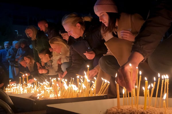 People light candles for the victims of the yesterdays, shooting rampage in Cetinje, in Podogrica, Montenegro, Thursday, Jan. 2, 2025. (AP Photo/Risto Bozovic)