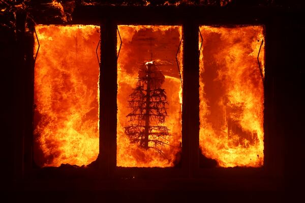 FILE - The Palisades Fire burns a Christmas tree inside a residence in the Pacific Palisades neighborhood of Los Angeles, Tuesday, Jan. 7, 2025. (AP Photo/Ethan Swope, File)