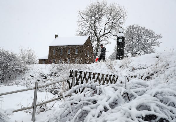 Lowson Robinson is pictured in the heavy snow with his scaled miniature famous landmarks which are located in his garden in Nenthead, England, as the severe weather continues across England, Sunday, Jan. 5, 2025. (AP Photo/Scott Heppell)