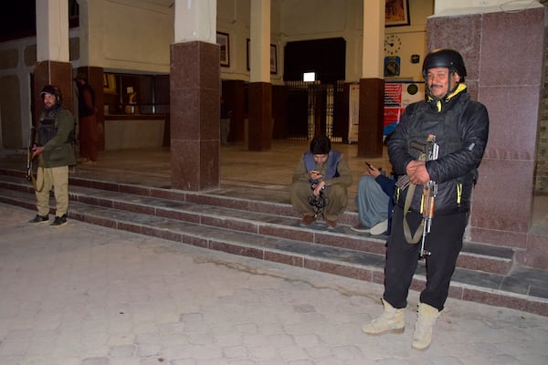 Police officers stand guard as members of media wait for the arrival of rescued passengers of a train attacked by insurgents, at a railway station in Quetta, Pakistan, Tuesday, March 11, 2025. (AP Photo/Arshad Butt)