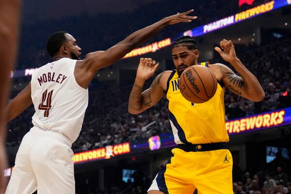 Cleveland Cavaliers forward Evan Mobley (4) knocks the ball away from Indiana Pacers forward Obi Toppin, right, in the first half of Game 1 in the Eastern Conference semifinals of the NBA basketball playoffs Sunday, May 4, 2025, in Cleveland. (AP Photo/Sue Ogrocki)