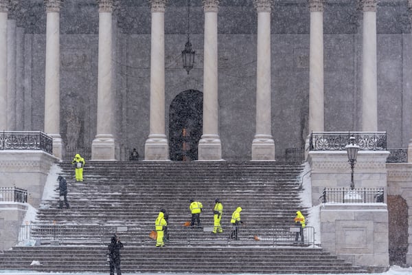 Workers clear steps at the Capitol as snow falls ahead of a joint session of Congress to certify the votes from the Electoral College in the presidential election, in Washington, Monday, Jan. 6, 2025. (AP Photo/J. Scott Applewhite)