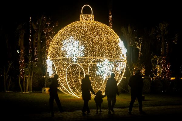 Egyptians walk in front of New Year decorations in Cairo, Egypt, Tuesday, Dec. 31, 2024. (AP Photo/Amr Nabil)