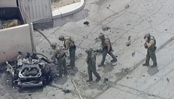 Law enforcement investigate a vehicle after an explosion on Saturday, May 17, 2025 in Palm Springs, Calif. (ABC7 Los Angeles via AP)