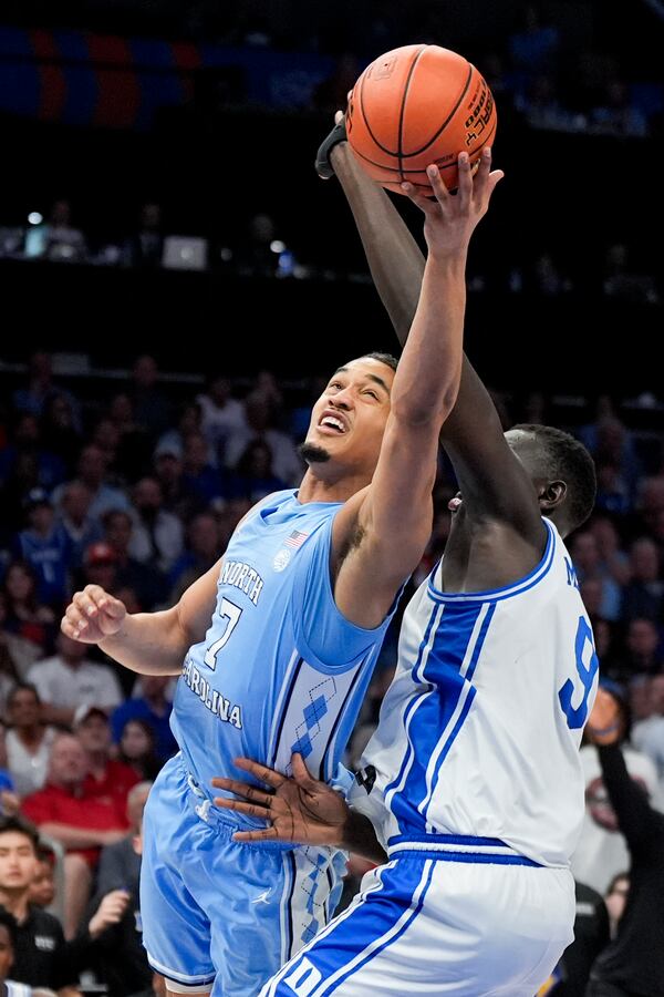 North Carolina guard Seth Trimble drives to the basket past Duke center Khaman Maluach during the first half of an NCAA college basketball game in the semifinals of the Atlantic Coast Conference tournament, Friday, March 14, 2025, in Charlotte, N.C. (AP Photo/Chris Carlson)