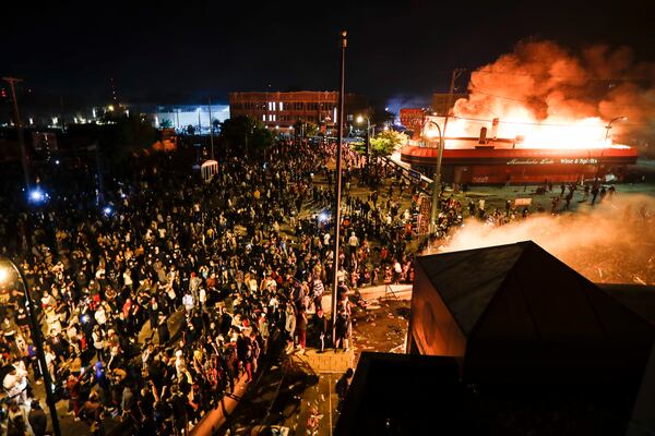 FILE - Protestors demonstrate outside of the burning Minneapolis 3rd Police Precinct in Minneapolis on May 28, 2020. (AP Photo/John Minchillo, File)