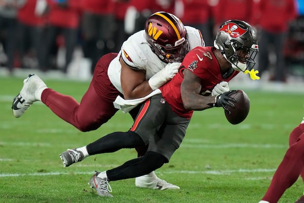 FILE- Tampa Bay Buccaneers running back Bucky Irving, right, runs against Washington Commanders defensive tackle Jonathan Allen during the second half of an NFL wild-card playoff football game in Tampa, Fla., Jan. 12, 2025. (AP Photo/Chris O'Meara, file)