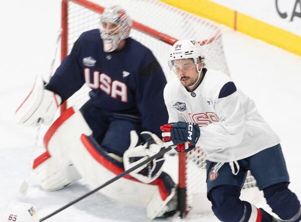 United States' Austin Matthews skates past goaltender Connor Hellebuyck during 4 Nations Face-Off hockey practice in Brossard, Quebec, on Monday, Feb. 10, 2025. (Christinne Muschi/The Canadian Press via AP)