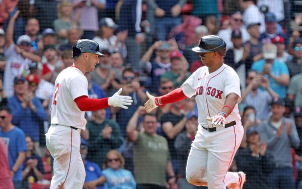 Boston Red Sox's Alex Bregman, left, congratulates teammate Rafael Devers, right, after his home run in the seventh inning of a baseball game against the Texas Rangers on Thursday May 8, 2025, in Boston. (AP Photo/Jim Davis)