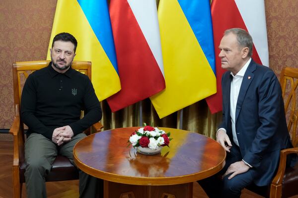 Polish Prime Minister Donald Tusk, right, speaks with Ukrainian President Volodymyr Zelenskyy after the two countries reached an agreement on a longstanding source of tensions between them: the exhumation of Polish victims of World War II-era massacres by Ukrainian nationalists, in Warsaw, Poland, on Wednesday, Jan. 15, 2025. (AP Photo/Czarek Sokolowski)