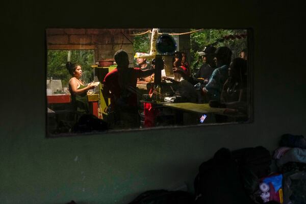 Venezuelan migrants buy food in Puerto Carti, on Panama's Caribbean coast, Saturday, Feb. 22, 2025, where they plan to board boats to Colombia after turning back from southern Mexico where they gave up hopes of reaching the U.S. amid President Trump's crackdown on migration. (AP Photo/Matias Delacroix)