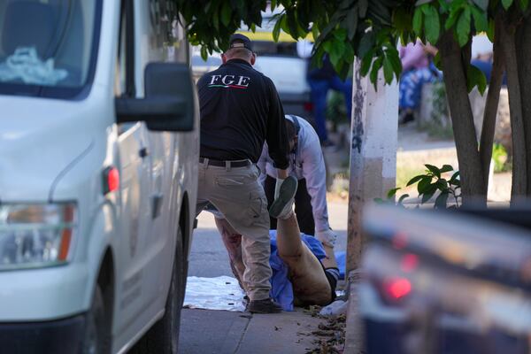 Forensic workers remove the body of the body of a slain woman in Culiacan, Mexico, Wednesday, Feb. 26, 2025. (AP Photo/Fernando Llano)