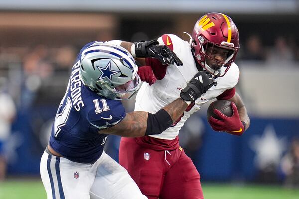 Washington Commanders cornerback Mike Sainristil, right, is pushed out of bounds by Dallas Cowboys linebacker Micah Parsons during the second half of an NFL football game, Sunday, Jan. 5, 2025, in Arlington, Texas. (AP Photo/Josh McSwain)