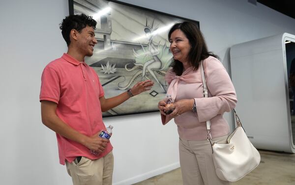 Florida International student Dylan Pravia, left, talks with Vicky Lazo, a teacher with Southwest Miami Senior High School, right, during a Hispanic Federation event in Miami, Tuesday, Jan. 28, 2025, where they announced a new investment from a company, to help Latinos learn digital skills. (AP Photo/Lynne Sladky)