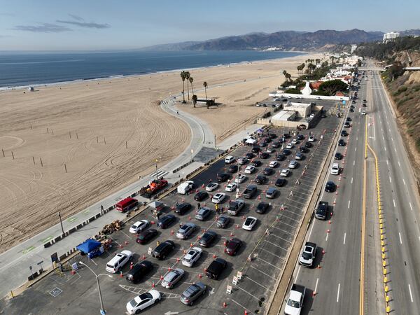 Motorists form a queue in a parking lot and along Pacific Coast Highway waiting to enter the Palisades Fire zone Tuesday, Jan. 28, 2025 in Santa Monica, Calif. (AP Photo/Jae C. Hong)